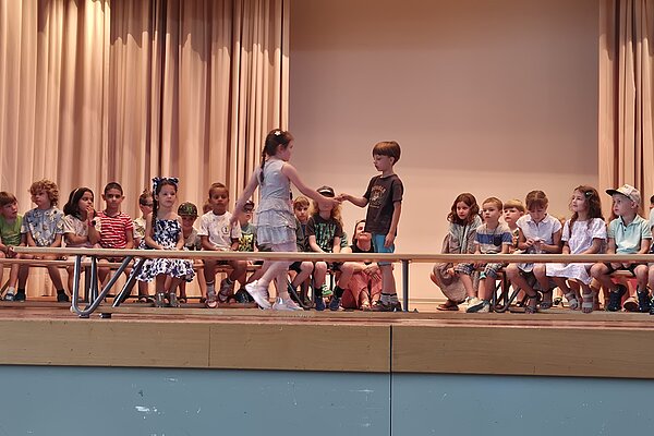 Mit Freude begrüssen die neuen ZweitklässlerInnen die neuen ErstklässlerInnen.